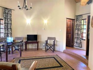 布拉瓦约Double lodge on natural African bush - 2112的客厅配有沙发、桌子和书桌