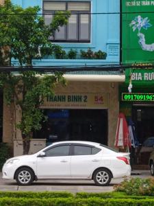 河静Hotel Thanh Bình 2的停在大楼前的白色汽车