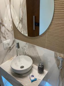 巴西利亚Flat Asa Norte CLN 311 by CentoEdez的浴室设有白色水槽和镜子