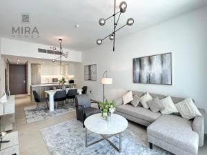 迪拜Mira Holiday Homes - Newly 2 bedroom in Dubai Marina with Canal View的客厅配有沙发和桌子