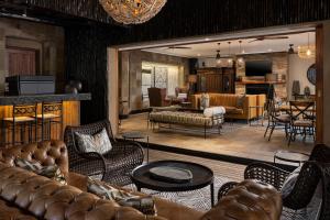 斯库库扎Kruger Gate Hotel的一间带真皮沙发的客厅和一间客厅