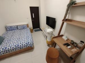 屏东县麟家民宿的一间小卧室,配有一张床和电视