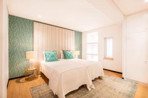 阿尔布费拉Pedro Mar的卧室配有带蓝色枕头的大型白色床