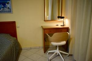 KhróniaEviaXL Studios的一间卧室配有一张桌子、一把椅子和一面镜子