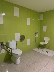 比拉尔瓦ALBERGUE CASTELOS VILALBA的绿色浴室设有卫生间和椅子