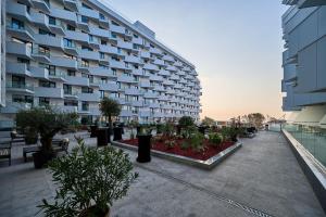北马马亚-讷沃达里Alezzi Infinity Aparthotel & Spa的大型公寓楼,设有种有植物的庭院