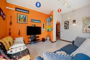 因佩里亚Ca dei Tati - Citra 1181的客厅设有橙色墙壁和电视