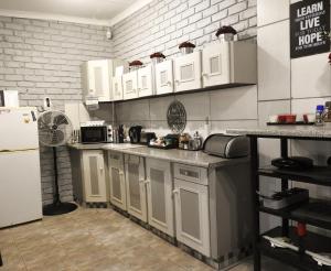 波切夫斯特鲁姆Spruitjie-roer-my-nie的厨房配有白色橱柜和冰箱。