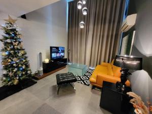 八打灵再也Empire Damansara Designer Soho Karaoke & Netflix的客厅配有圣诞树和沙发