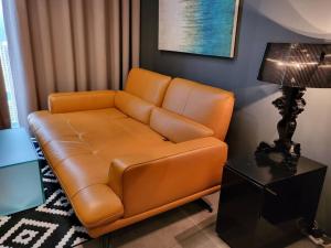 八打灵再也Empire Damansara Designer Soho Karaoke & Netflix的客厅里一张棕色的皮沙发,配有灯