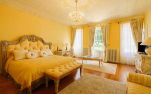 马尔戈Hôtel de Margaux的一间卧室配有一张黄色墙壁和吊灯的床。
