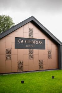 库尔迪加Hotel Gothards的建筑的侧面有标志