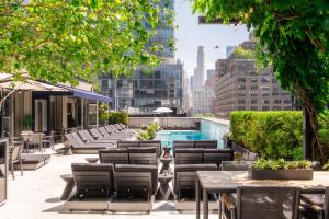 纽约多米尼克酒店的一个带桌椅的屋顶露台和游泳池
