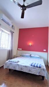 坎多林Monte Villa Guest House的一间卧室配有一张红色墙壁的床