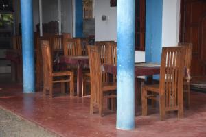 蒂瑟默哈拉默Tashil Hotel & Restaurant的一张木桌、木椅和蓝色的柱子