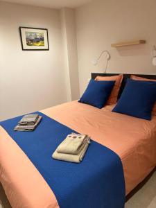 圣热尔韦莱班Residencecalou的一张带蓝色和橙色床单和蓝色枕头的床