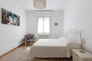 博洛尼亚A Casa di Giorgia by Wonderful Italy的白色卧室配有床和椅子