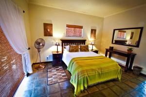 奥奇瓦龙戈欧吉瓦萨法里山林小屋的一间卧室配有一张床和风扇