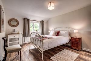 比斯特Meadow Cottage的卧室配有床、椅子和窗户。