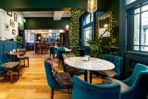 哈罗盖特The Inn at Cheltenham Parade的一间设有蓝色椅子和桌子的餐厅