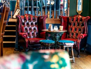 哈罗盖特The Inn at Cheltenham Parade的房间里的两张椅子和一张桌子