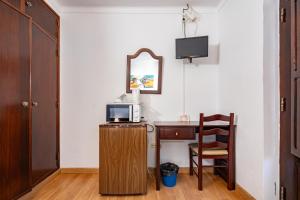 米尔芳提斯城Apartamentos Pátio Victória by Umbral的客房设有带微波炉的书桌和椅子。