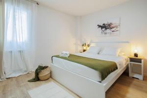 马德里GENESIS APARTMENT IN MADRID的白色的卧室设有一张大床和一个窗户