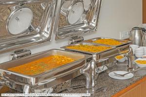 班加罗尔Treebo Trend Apple Villa的厨房柜台上装满食物的两个金属锅