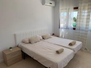 卡尔佩Casa los Pinos Calpe Playa的一间卧室配有一张大白色床和两个枕头