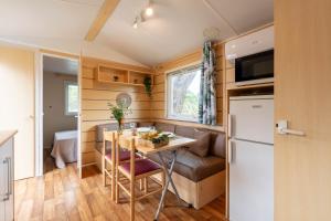 耶尔Le Photinia, mobil-home climatisé avec vue mer situé au cœur du domaine的一间小房子里的小厨房和饭厅