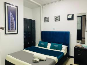 波哥大Hotel Bogota Home的一间卧室配有两张带蓝白色枕头的床
