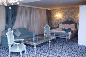 甘贾Deluxe Hotel Ganja的酒店客房配有床、沙发和桌子。