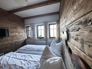 旧明斯特Gmundnerberghaus的一间卧室设有两张床和木墙