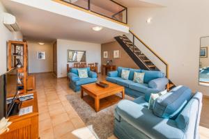 卢斯Estrela da Luz Resort的客厅设有蓝色的沙发和楼梯。