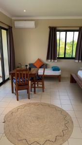 江比阿Coral House near Villa Bluu的客厅配有桌子和床。