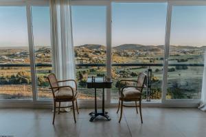 坦迪尔Amaike Hotel Golf & Spa的带窗户的客房内配有两把椅子和一张桌子