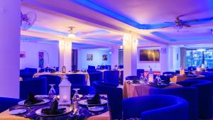 蒙巴萨Hotel Sapphire的宴会厅配有桌子和蓝色椅子