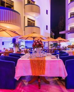 蒙巴萨Hotel Sapphire的餐厅的桌子,椅子和遮阳伞