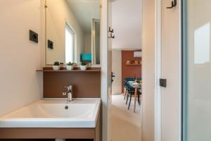 耶尔Le Palmier, mobil-home sans vis-à-vis idéalement situé entre mer et vignes的一间带水槽的浴室和一间餐厅