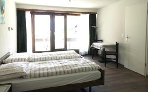 翁根博纳霍夫公寓式酒店的一间卧室配有一张床、一个窗口和一张书桌