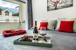 纳图尔诺Apartment il cuore rosso的床上托盘上的一瓶葡萄酒和葡萄