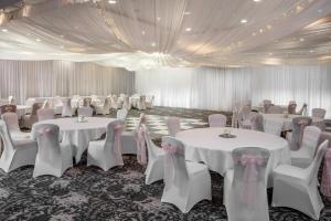 萨顿·斯科特尼Norton Park Hotel, Spa & Manor House - Winchester的宴会厅配有白色的桌椅和天花板