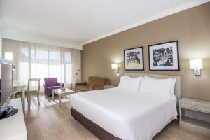 卡利卡利皇家NH酒店 的一间带白色大床的卧室和一间客厅