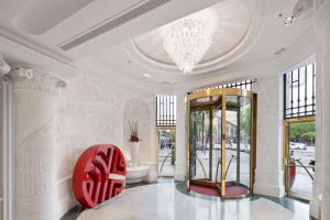 马德里马德里普拉多大道NH精品酒店的大堂配有吊灯和红色椅子