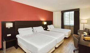 科英布拉NH Coimbra Dona Ines的酒店客房,配有两张床和椅子