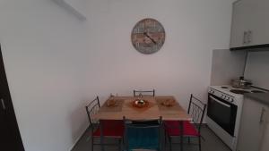 罗希姆诺Sweet Home的厨房配有桌子和墙上的时钟