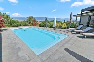 屈德勒凡Magnifique villa avec piscine et vue sur le lac的一个带2把躺椅的游泳池以及1栋房子