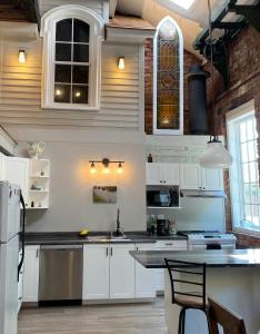 皮克图Olde Foundry Apt的厨房配有白色橱柜和台面