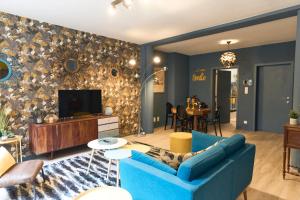蒙斯Le Vintage coup de coeur !的客厅配有蓝色的沙发和电视