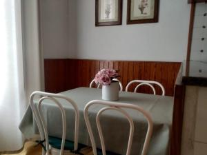 圣卡洛斯拉腊皮塔Alfacs的一张桌子,上面有两把椅子和花瓶